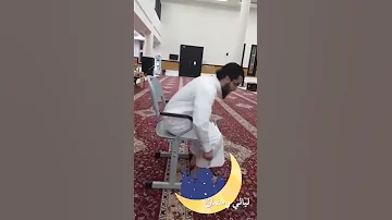 [EN] A chair in the mosque for the elderly and infirm stands in line and does not disturb those standing behind